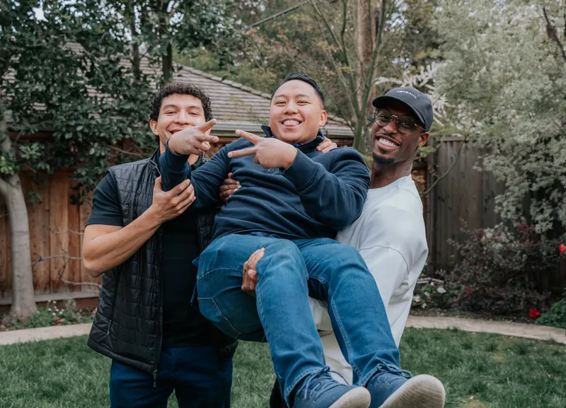 Friends lifting a guest off the ground at a graduation party