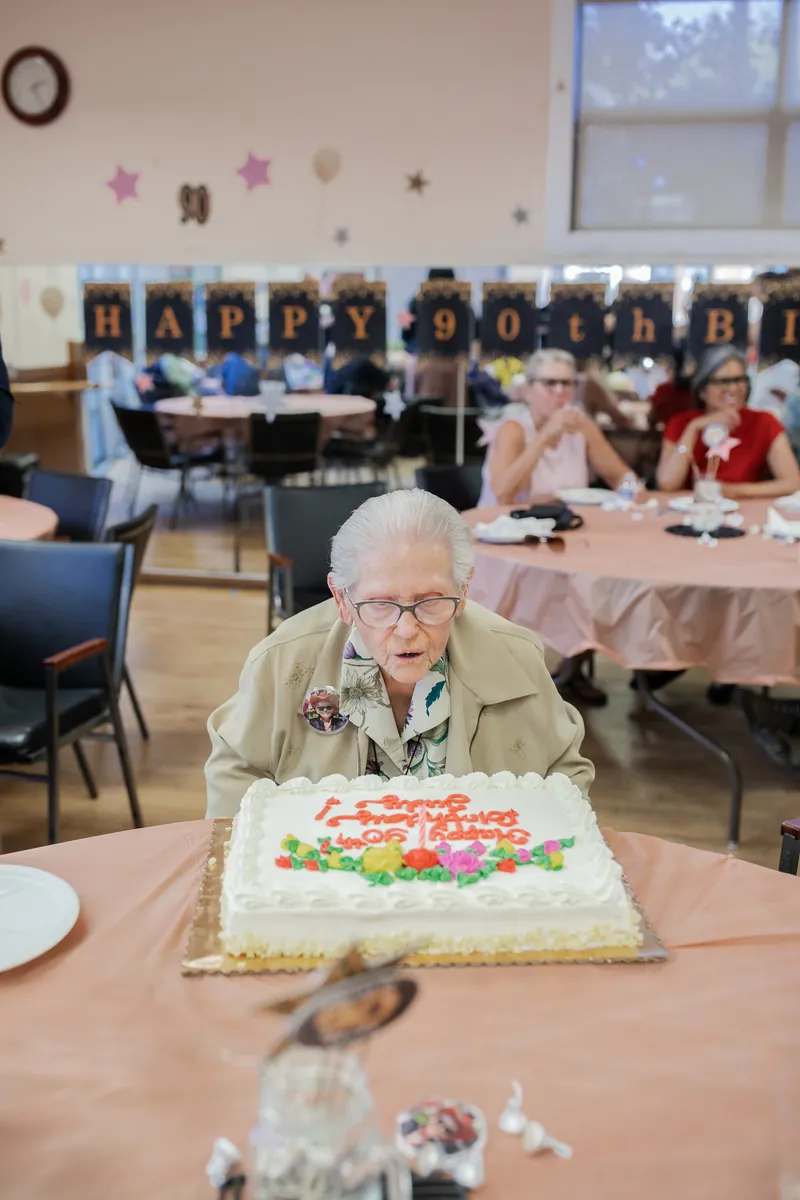 The guest of honor and her cake at a 90th birthday party