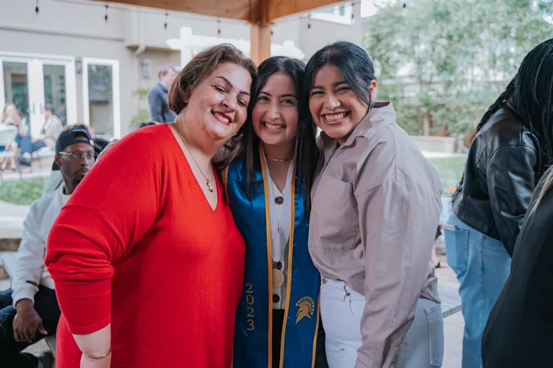 The graduate between two smiling guests