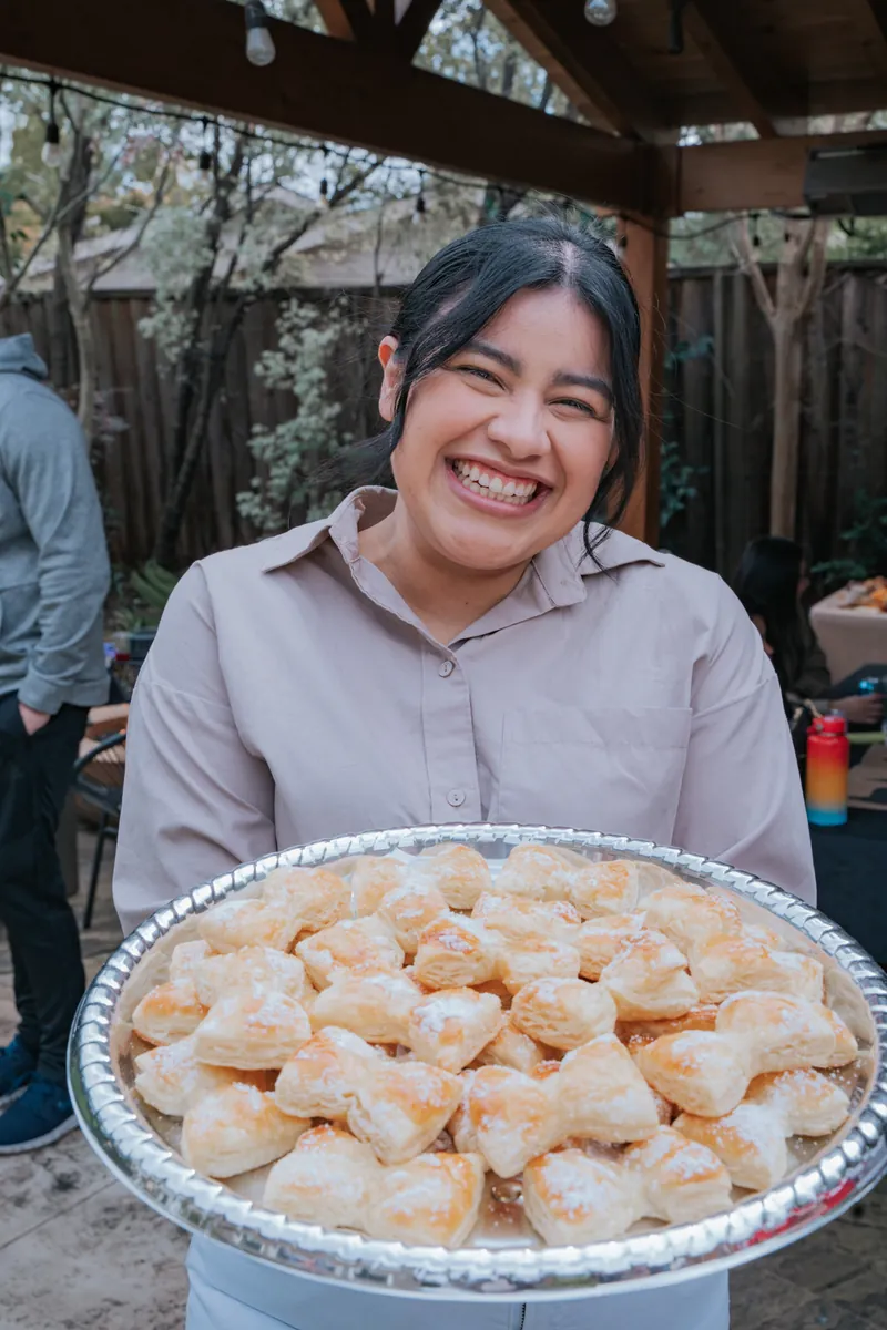 A guest holding a tray of pastries at a graduation party