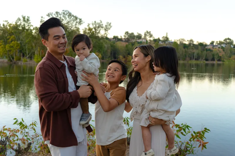 A family laughing together by the lake