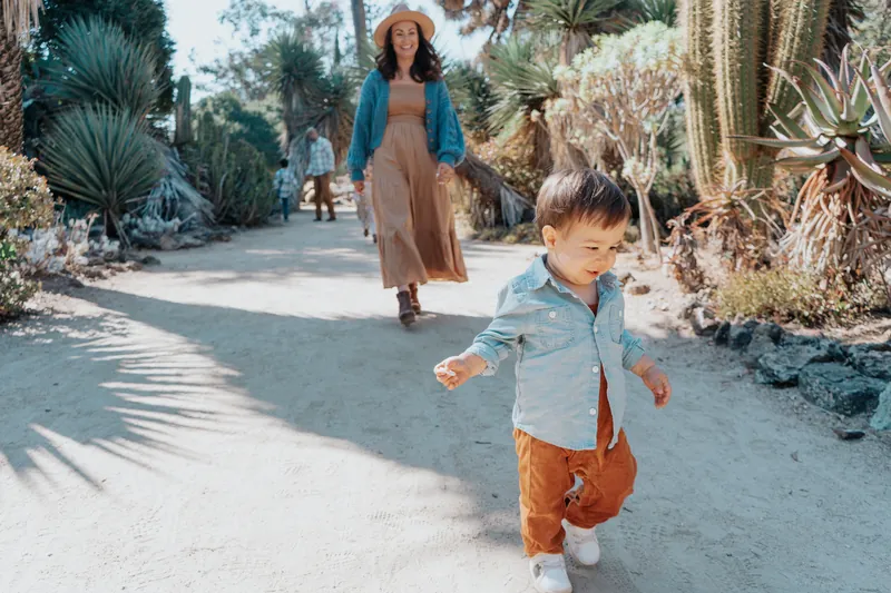 A toddler running ahead of mom