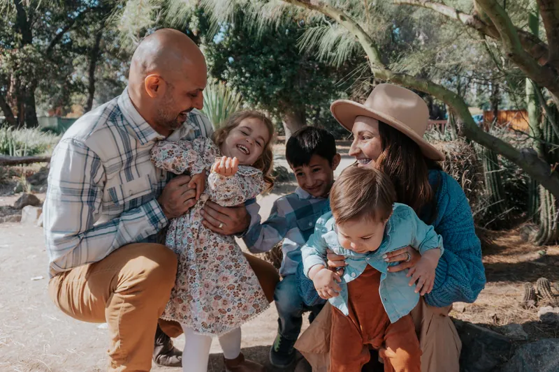 A family huddled together, kids mid-giggle