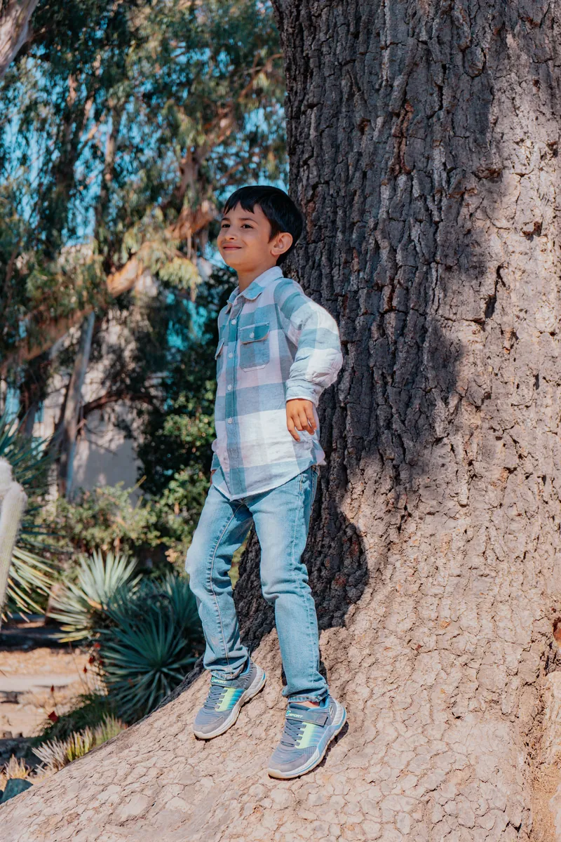 A boy jumping down from a tree