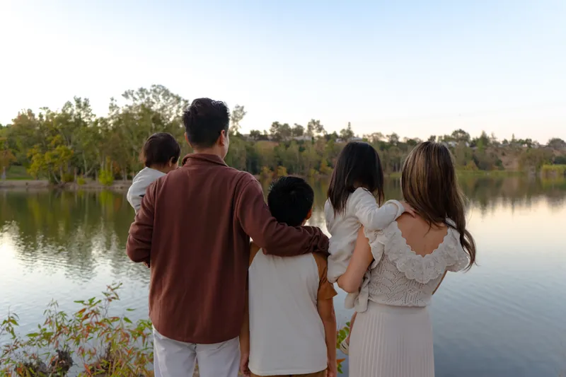 A family looking out at the lake, seen from behind