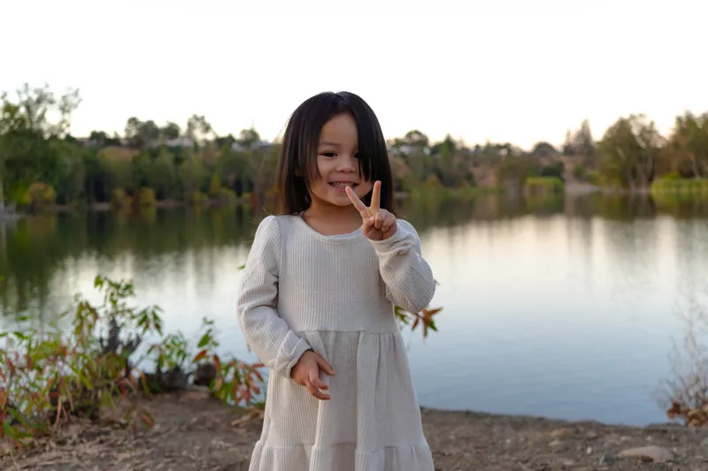 A little girl making a peace sign