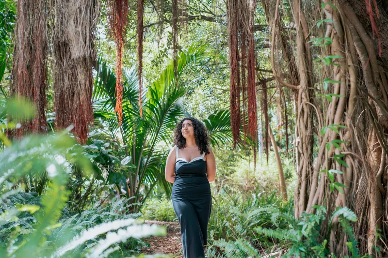 A senior walking under hanging roots in a garden