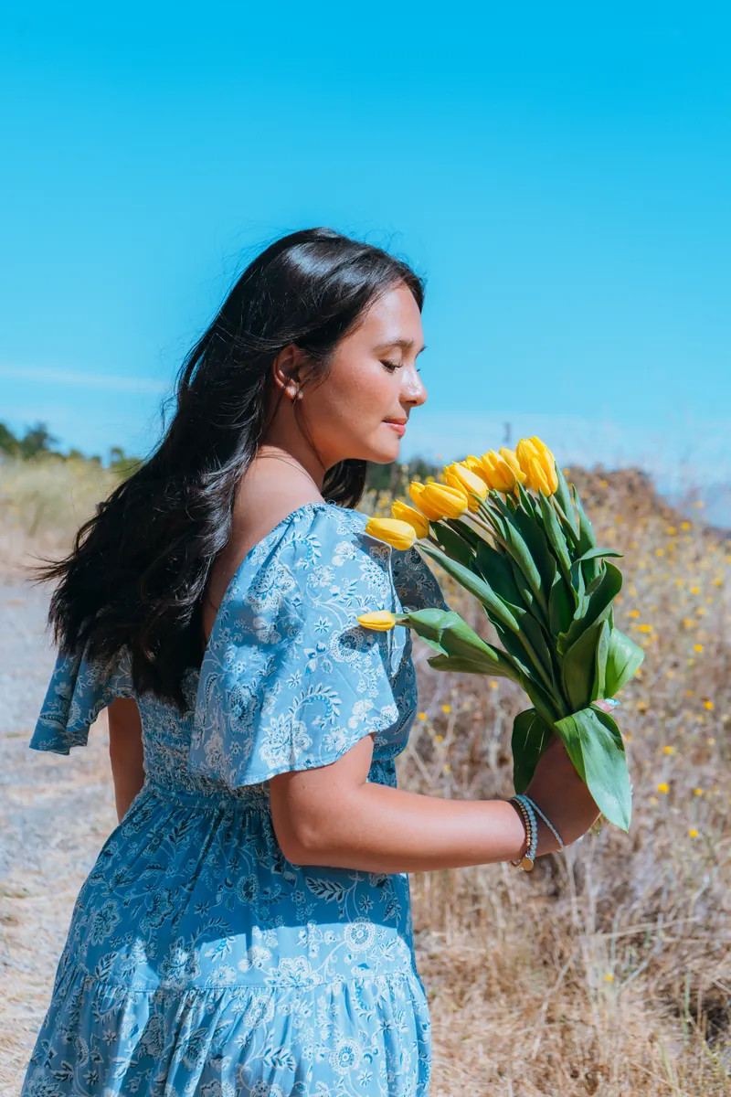 Holding yellow tulips in a blue dress