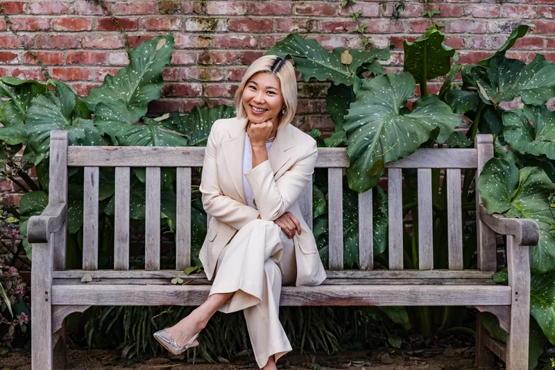 Seated on a garden bench against a brick wall