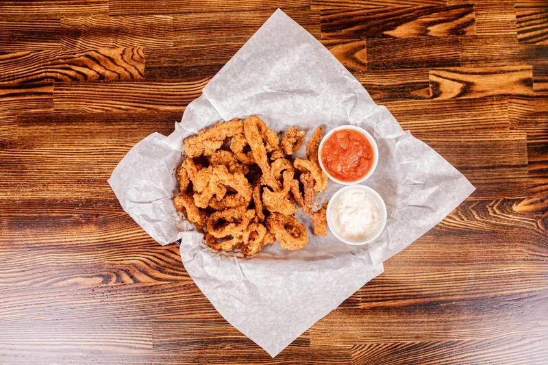 Fried calamari on paper with two dipping sauces, from above