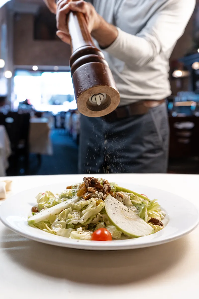 Fresh pepper ground over a salad at the table
