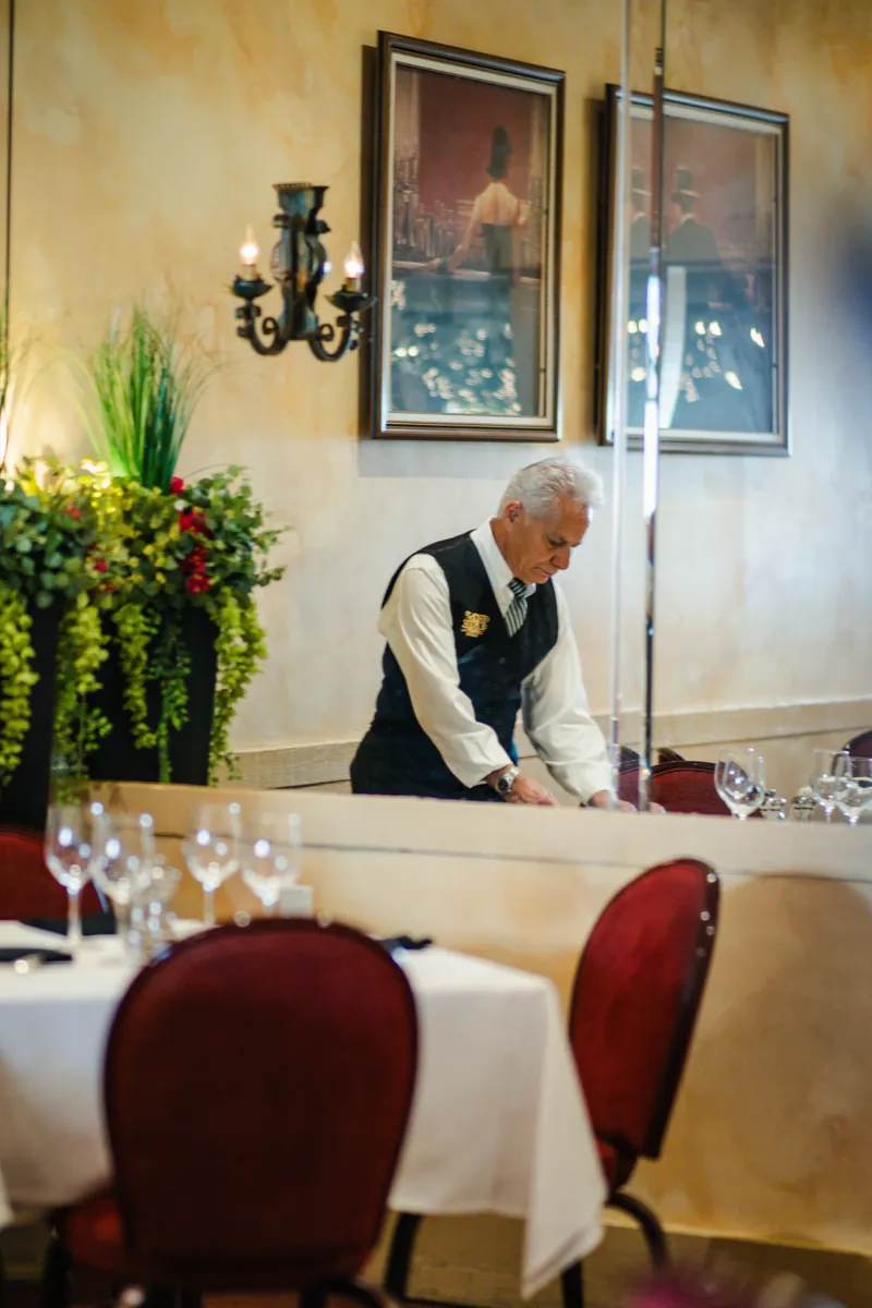 A server setting a table in the dining room