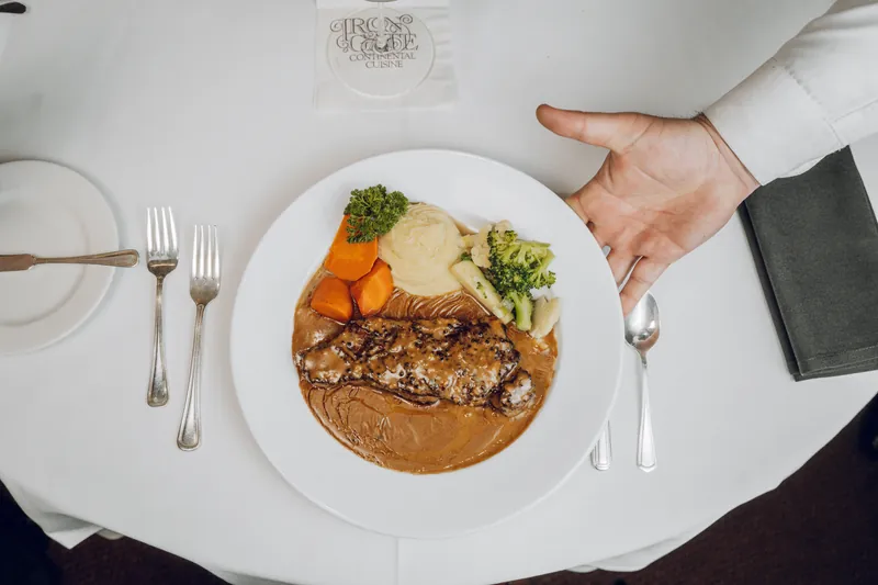 A plate, a glass of wine, and an Iron Gate napkin from above