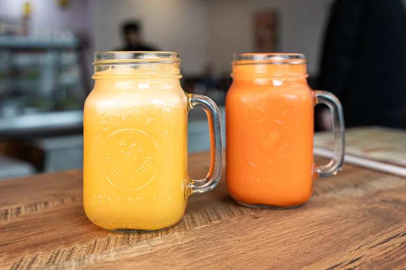 Fresh orange and carrot juice in glass mugs