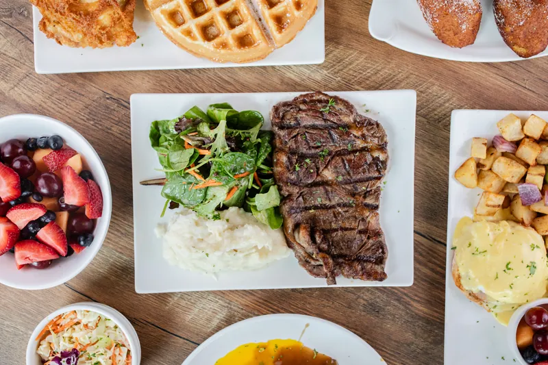 An overhead spread of steak, salad, and sides